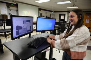 A high school girl uses a computer aided drafting program to design an ADA-compliant home