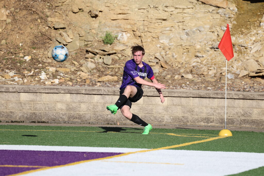 A member of the boys soccer team kicks a ball at Bracewell Stadium