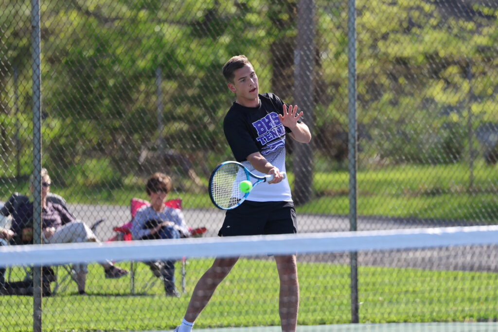 A member of the boys tennis team swings at a ball during a match