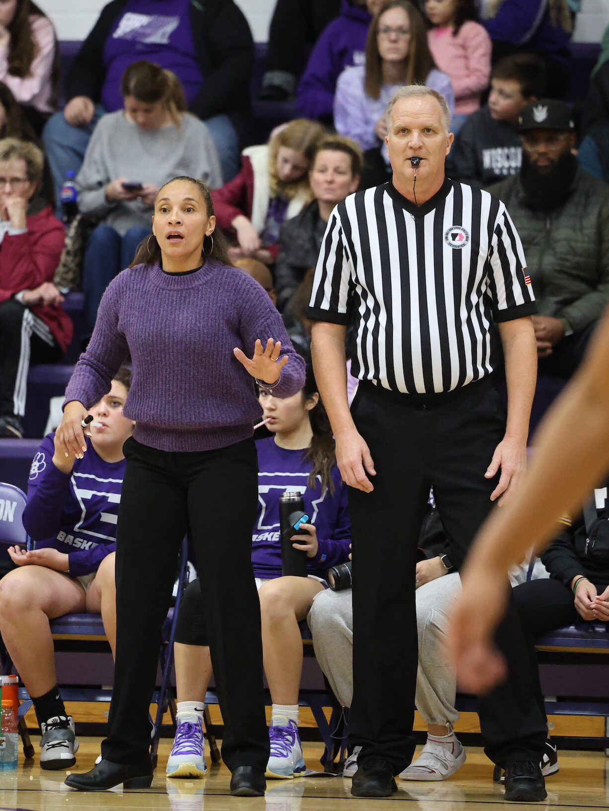 Coach Adriana Mafra signals to her players during a basketball game.