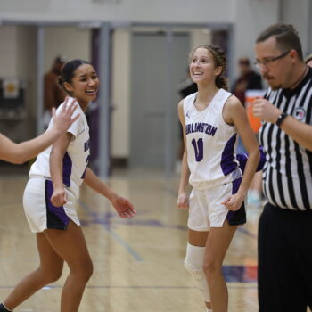 Members of the girls basketball team smile after making a three-point basket.