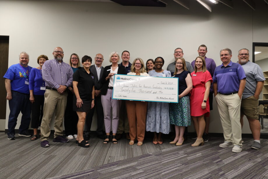 Representatives for Molina Healthcare, iJAG, Burlington High School and BCSD pose for a photo while holding up a giant check in the amount of $25,000 from Molina Cares to iJAG.