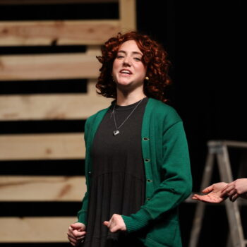 A student actress dressed as Annie sings while performing in the fall production of 