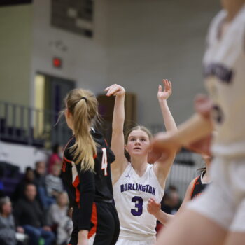 A basketball player's arms remain in the air for a moment after shooting a basket