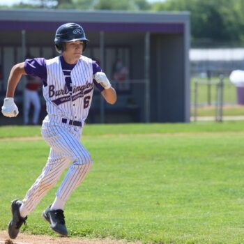 A baseball player runs to first base during a baseball game.