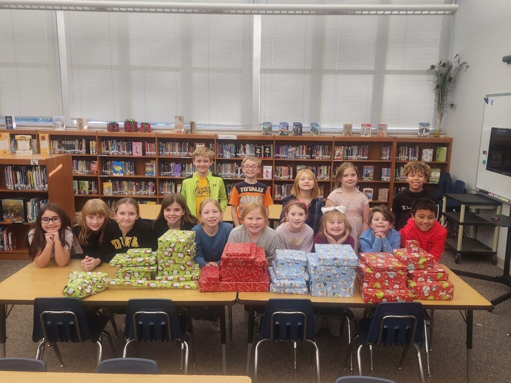 Members of Black Hawk Elementary School’s Student Council pose for a photo alongside gifts they purchased and wrapped for a family they adopted for the holidays. They raised money for the gifts by selling water bottle stickers and candy canes.