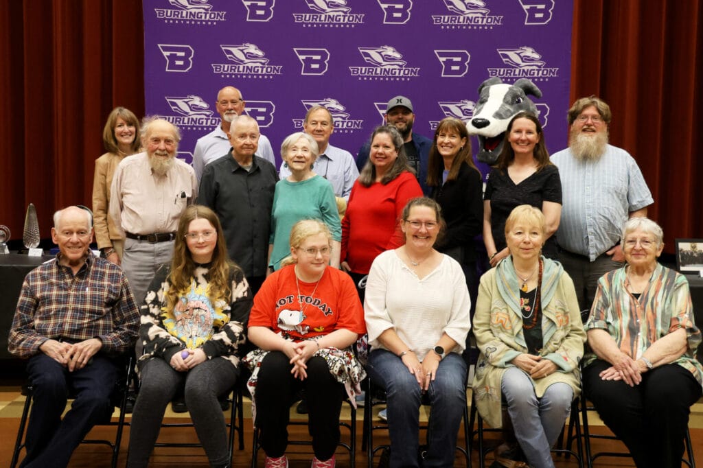 Members of the late Dr. Edward Stone’s family pose for a photo alongside Homer Monday, April 28, 2025, during Student Spotlight in the auditorium at Edward Stone Middle School, where more than 30 items donated to the school by the family were on display. These items will be displayed at the school and other locations throughout the community in the near future. 