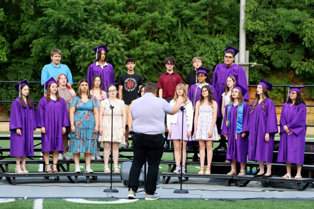Choir members sing during Burlington High School's 2025 commencement ceremony at Bracewell Stadium.