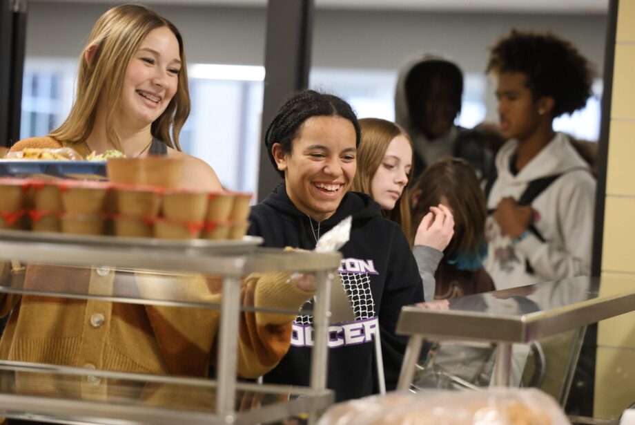 Students smile while going through the lunch line Nov. 14, 2024, at Burlington High School. Kelly Pfeifer, who is in her first year as kitchen manager, has been working to bring new items to the menu.