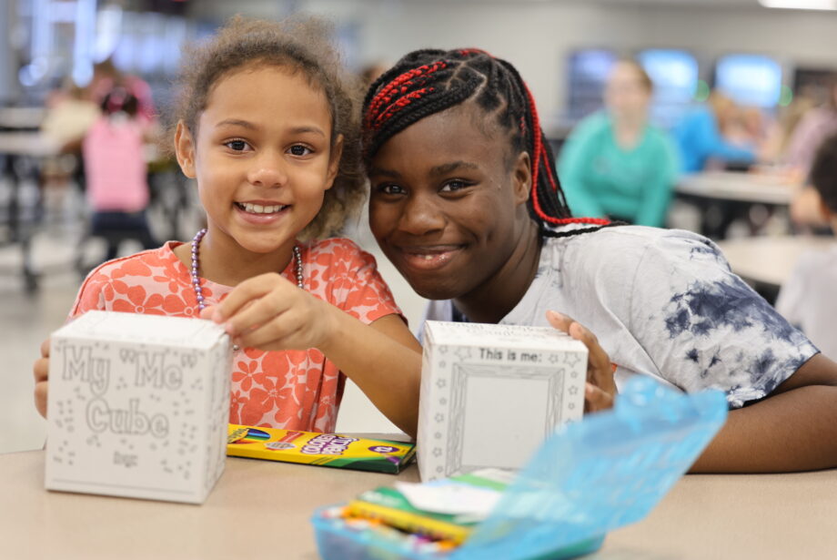 A high school mentor and her elementary age mentee pose for a photo during their first Club M meeting of the school year.