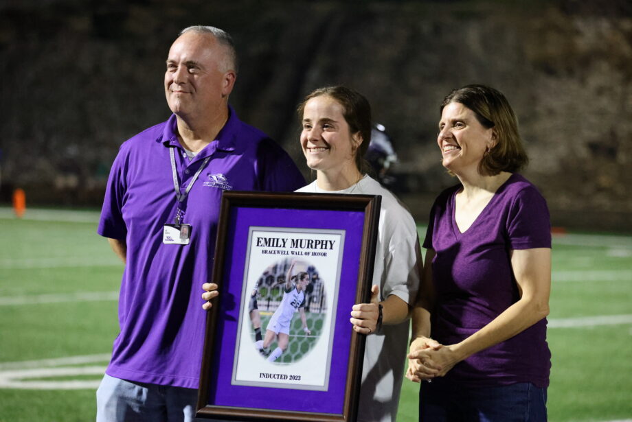 Emily Murphy stands between her parents, Derrick Murphy and June Kauder, Friday, Sept. 29, at Bracewell Stadium after being inducted onto the Bracewell Stadium Wall of Honor.