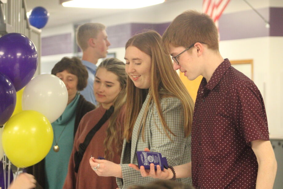 Attendees of the Burlington High School National Honor Society chapter line up to claim prizes Thursday, March 23, 2023, during a round of NHS Bingo, which was part of the chapter's 100th birthday celebration at the BHS library. Below: NHS photos are displayed on a table ahead of the celebration.