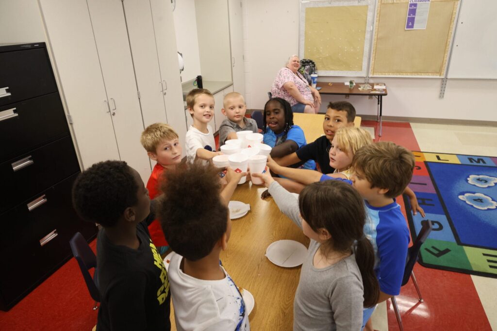 Third- (now fourth-)graders gather for a toast to fourth grade Aug. 1, 2024, as they finish their pizza party made possible by Deron Bray’s mother, Darlene, who purchased the pizzas to help her son and his classmates celebrate their last day of summer school. “My favorite thing about summer school is the family-like atmosphere,” interventionist and summer school teacher Judy White said. 