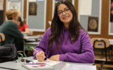 Sarra Yahyaoui, 16, smiles for a photo while drawing during her 2-D Art class in Anthony Onesto’s classroom at Burlington High School. Yahyaoui is one of six foreign exchange students studying at BHS this year. A math major back home, this is her first time taking an art class.