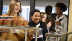 Students smile while going through the lunch line Nov. 14, 2024, at Burlington High School. Kelly Pfeifer, who is in her first year as kitchen manager, has been working to bring new items to the menu.