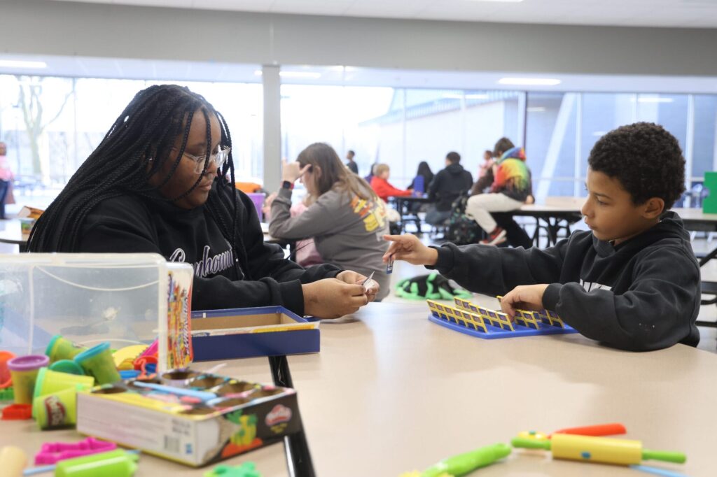 Burlington High School freshman Xyian Parker and third-grader Josiah Carpenter play “Guess Who” Jan. 15, 2025, in the cafeteria at BHS. “One of the good things about being a mentor is that I get to give other people opportunities to do things that I didn’t have,” Parker said.