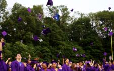 Purple caps fly up in the air as graduates face the crowd at the close of Burlington High School's 2025 commencement ceremony at Bracewell Stadium.