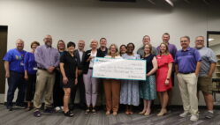 Representatives for Molina Healthcare, iJAG, Burlington High School and BCSD pose for a photo while holding up a giant check in the amount of $25,000 from Molina Cares to iJAG.