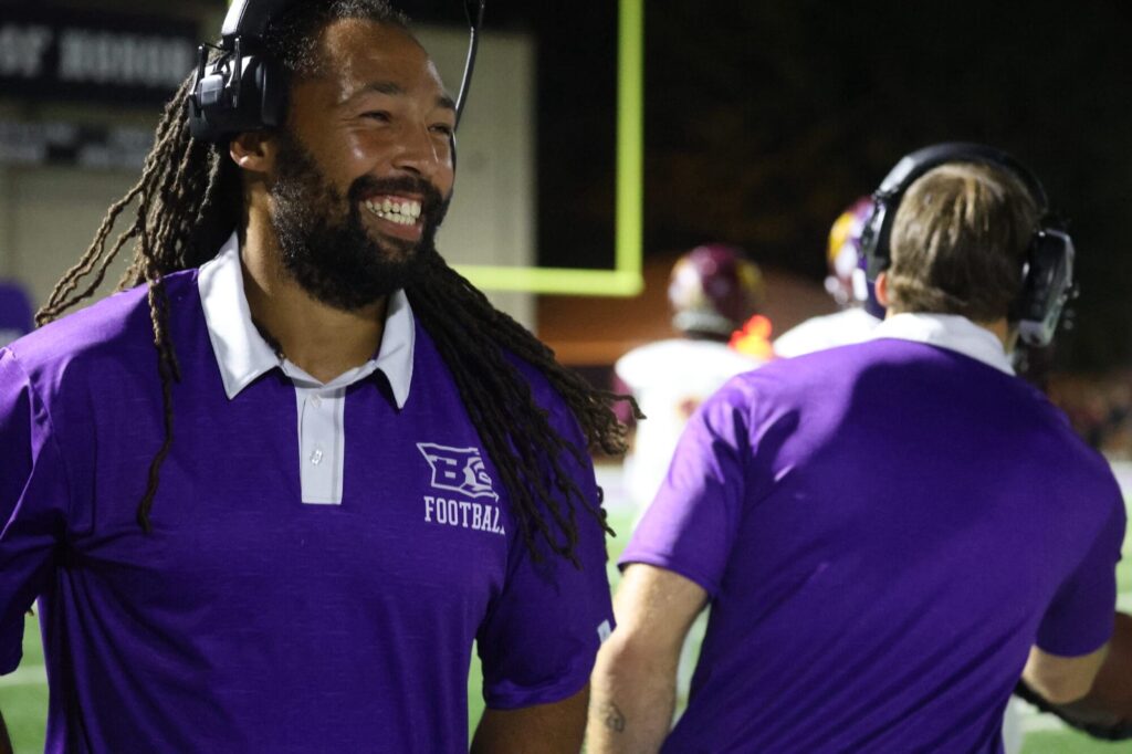 Head football coach Jordan Webb, a 2011 graduate of BHS, smiles after the Grayhounds score a touchdown against Mount Pleasant during the Homecoming game.  