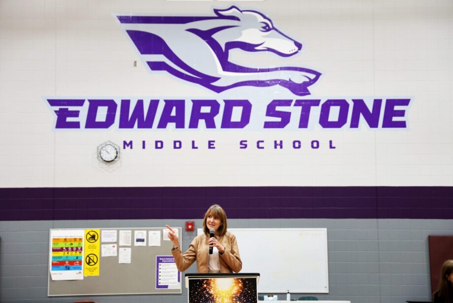 Janet Stone addresses community members, staff and students gathered Monday, April 28, 2025, for Student Spotlight at Edward Stone Middle School. The daughter of the late Dr. Edward Stone, she was among nearly 20 Stone family members who traveled to Burlington for the event, which featured more than 100 student projects along with items donated to the school by the Stone family.