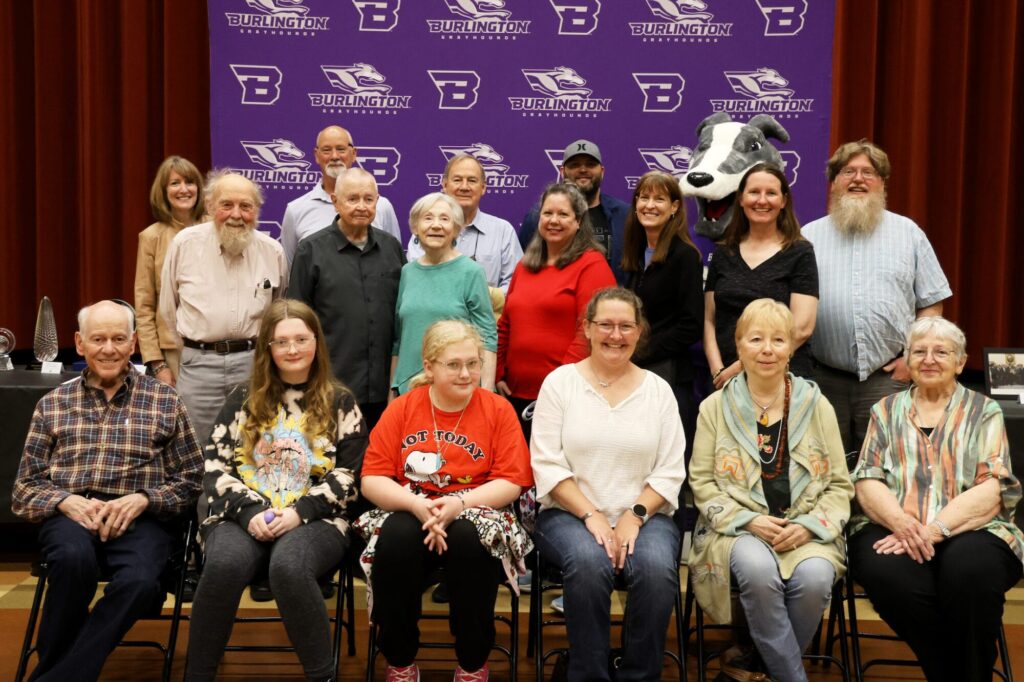 Members of the late Dr. Edward Stone’s family pose for a photo alongside Homer Monday, April 28, 2025, during Student Spotlight in the auditorium at Edward Stone Middle School, where more than 30 items donated to the school by the family were on display. These items will be displayed at the school and other locations throughout the community in the near future. 