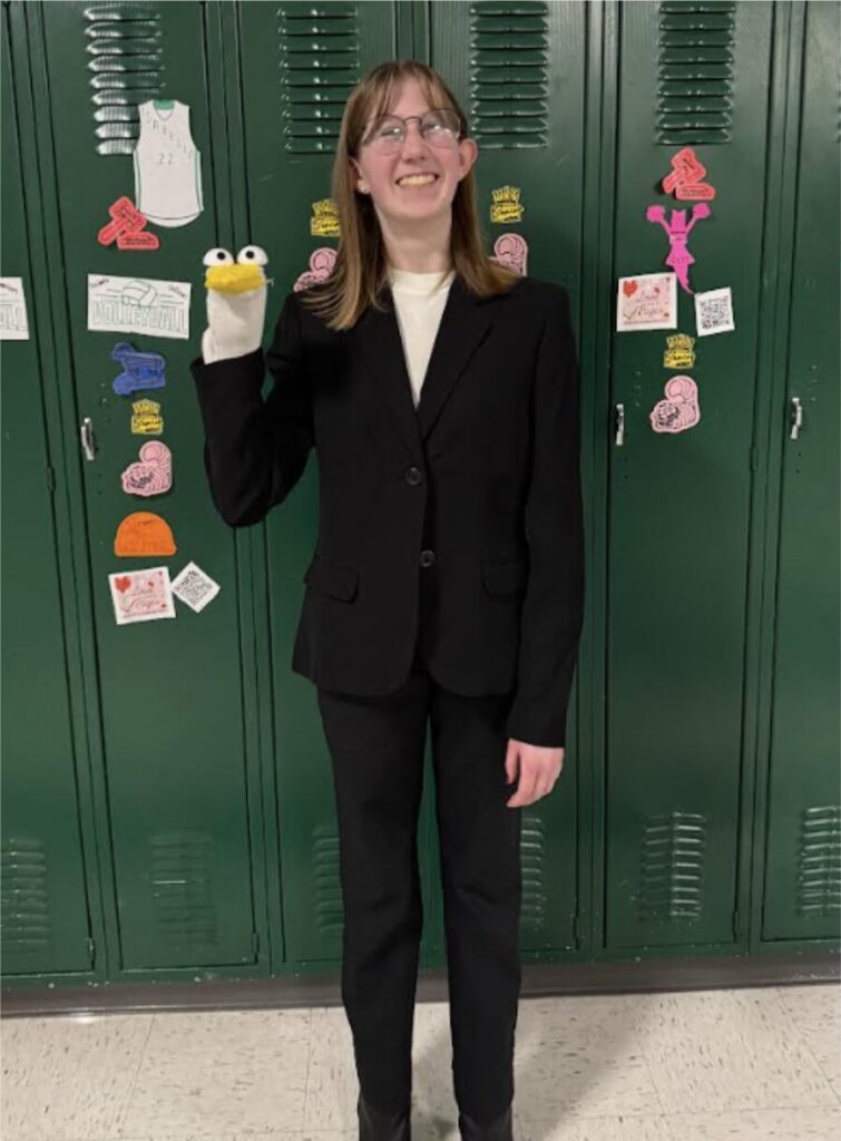 Miriam Petersen poses with her puppet used in her Informative Speaking speech on Puppetry. 