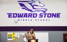 Janet Stone addresses community members, staff and students gathered Monday, April 28, 2025, for Student Spotlight at Edward Stone Middle School. The daughter of the late Dr. Edward Stone, she was among nearly 20 Stone family members who traveled to Burlington for the event, which featured more than 100 student projects along with items donated to the school by the Stone family.