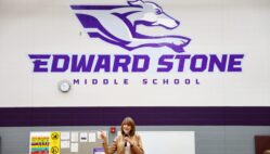 Janet Stone addresses community members, staff and students gathered Monday, April 28, 2025, for Student Spotlight at Edward Stone Middle School. The daughter of the late Dr. Edward Stone, she was among nearly 20 Stone family members who traveled to Burlington for the event, which featured more than 100 student projects along with items donated to the school by the Stone family.