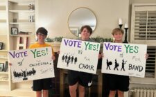 Three former and current Burlington High School students hold signs encouraging voters to cast ballots in favor of a proposed VPPEL increase to fund the expansion of the Aldo Leopold Intermediate School Auditorium. The photo was posted to the BHS Music Boosters Facebook page and is among many posts the boosters made in support of the measure leading up to the special election.