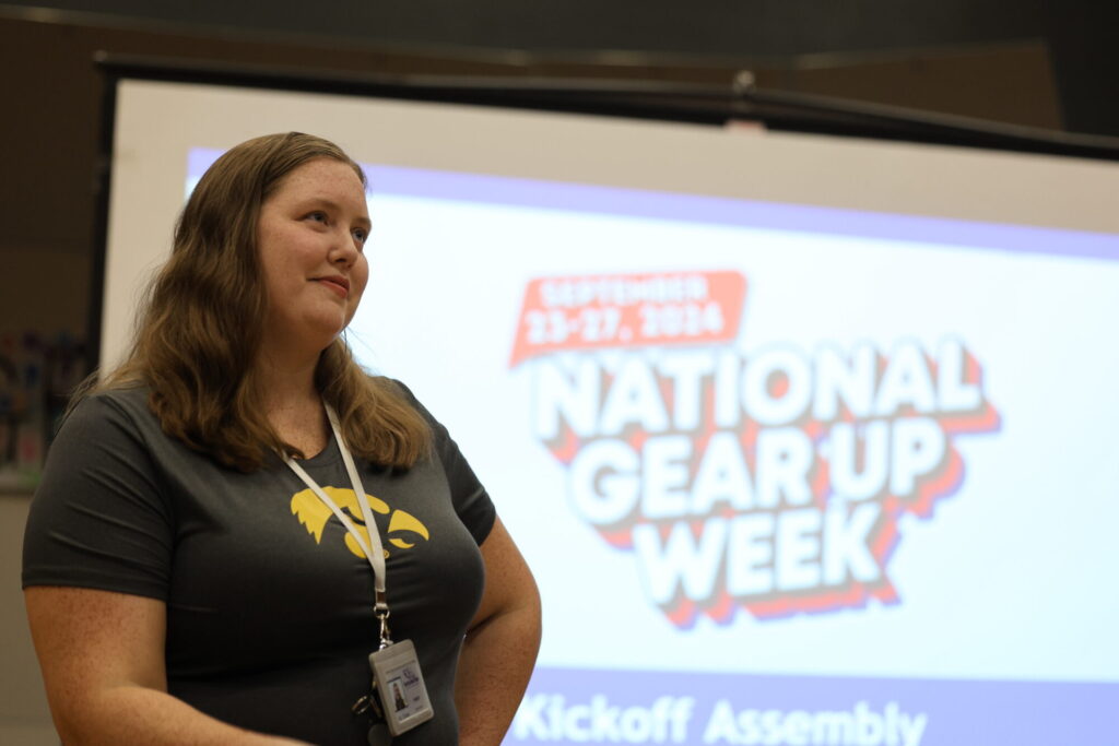 GEAR UP Iowa coach Ivy Tranter stands before an auditorium full of eighth-graders Sept. 26, 2024, ahead of an assembly to celebrate National GEAR UP Week at Edward Stone Middle School.  