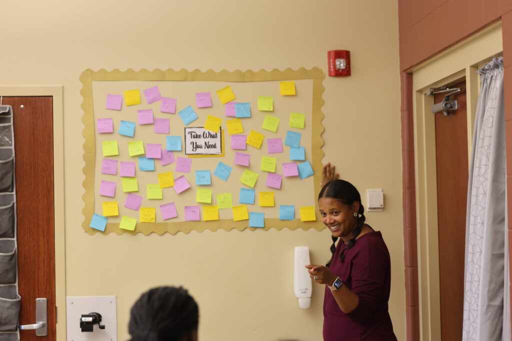  Cree Webb, a social services specialist and 2007 graduate of Burlington High School, stands in front of the “Take What You Need” board Sept. 19, 2024, in her office at Aldo Leopold Intermediate School. The board is filled with notes written by students that are available to anyone in need of a kind word.